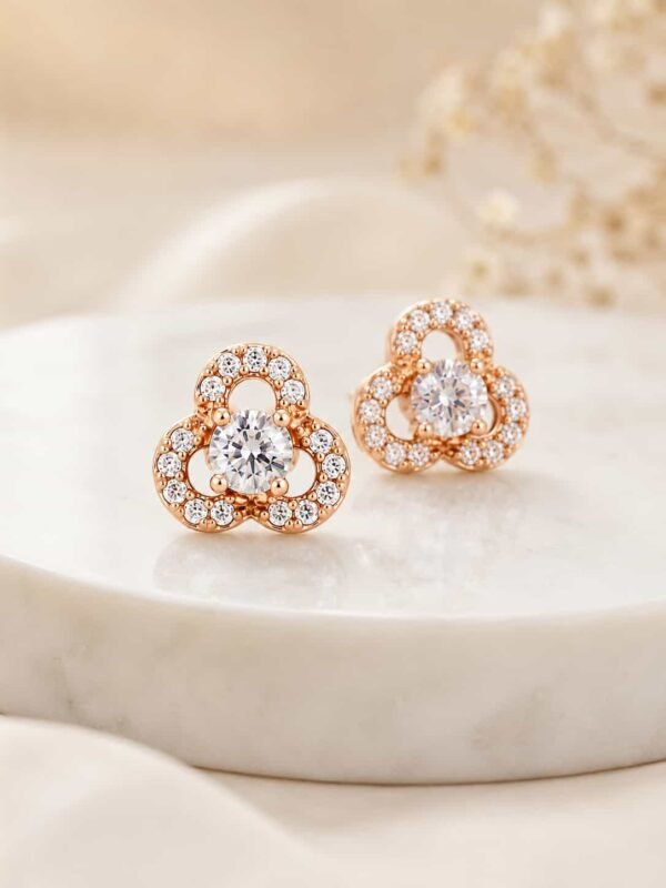 Close-up of rose gold floral halo stud earrings with round centre stones and sparkling three-petal design