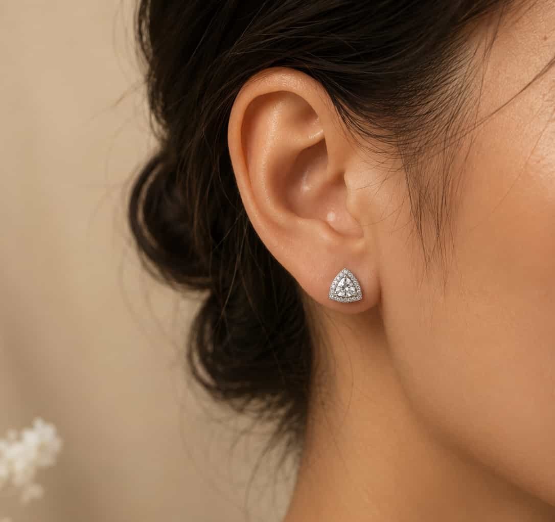 Woman wearing Celeste platinum polished triangle halo stud earring