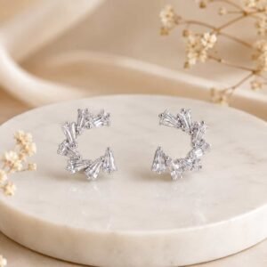 Crystal fan open hoop earrings with tapered clear stones displayed on a cream marble jewellery stand