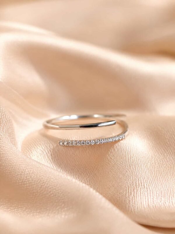 Naira platinum-polished double-row open wrap ring with sparkling clear stones displayed on champagne satin