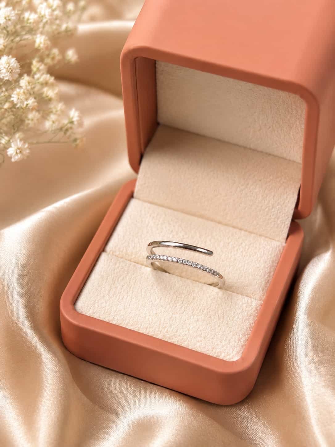 Naira platinum-polished double-row open wrap ring styled in a coral jewellery box on champagne satin
