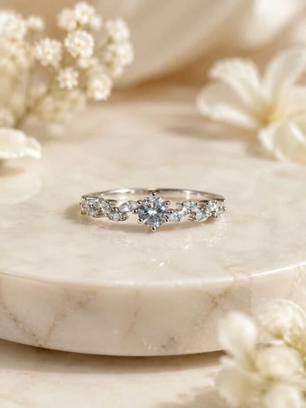 Fiora platinum-polished floral solitaire ring displayed on white marble with soft ivory flowers