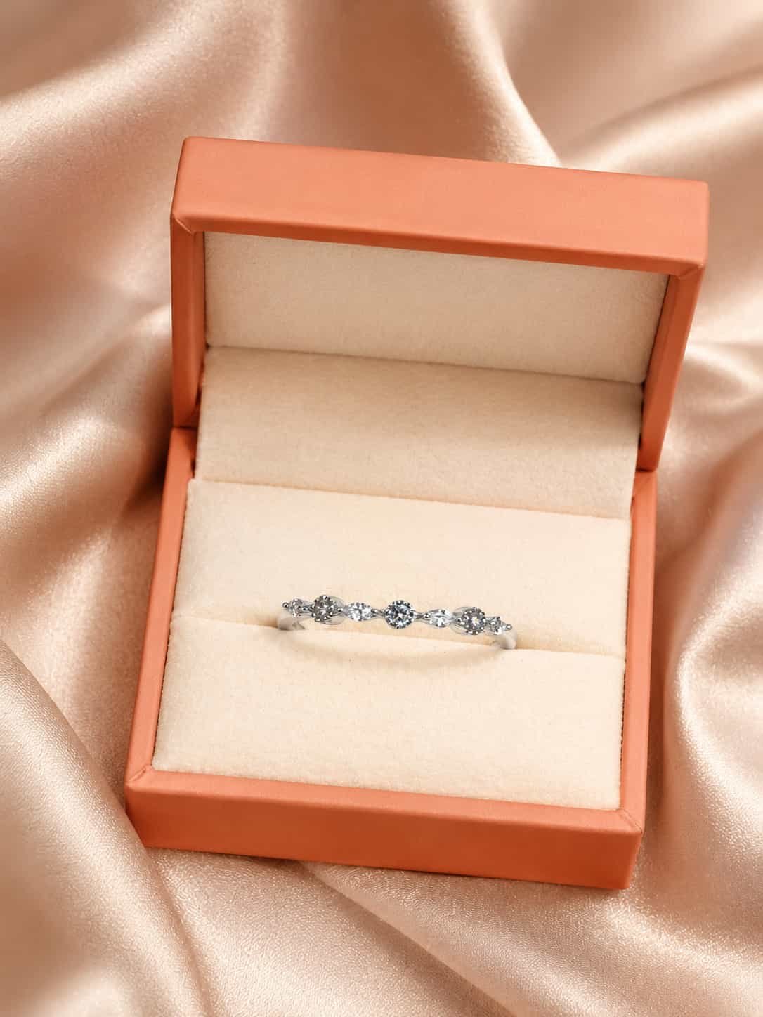 Liora round and marquise sparkle ring presented inside an orange jewellery gift box on champagne satin