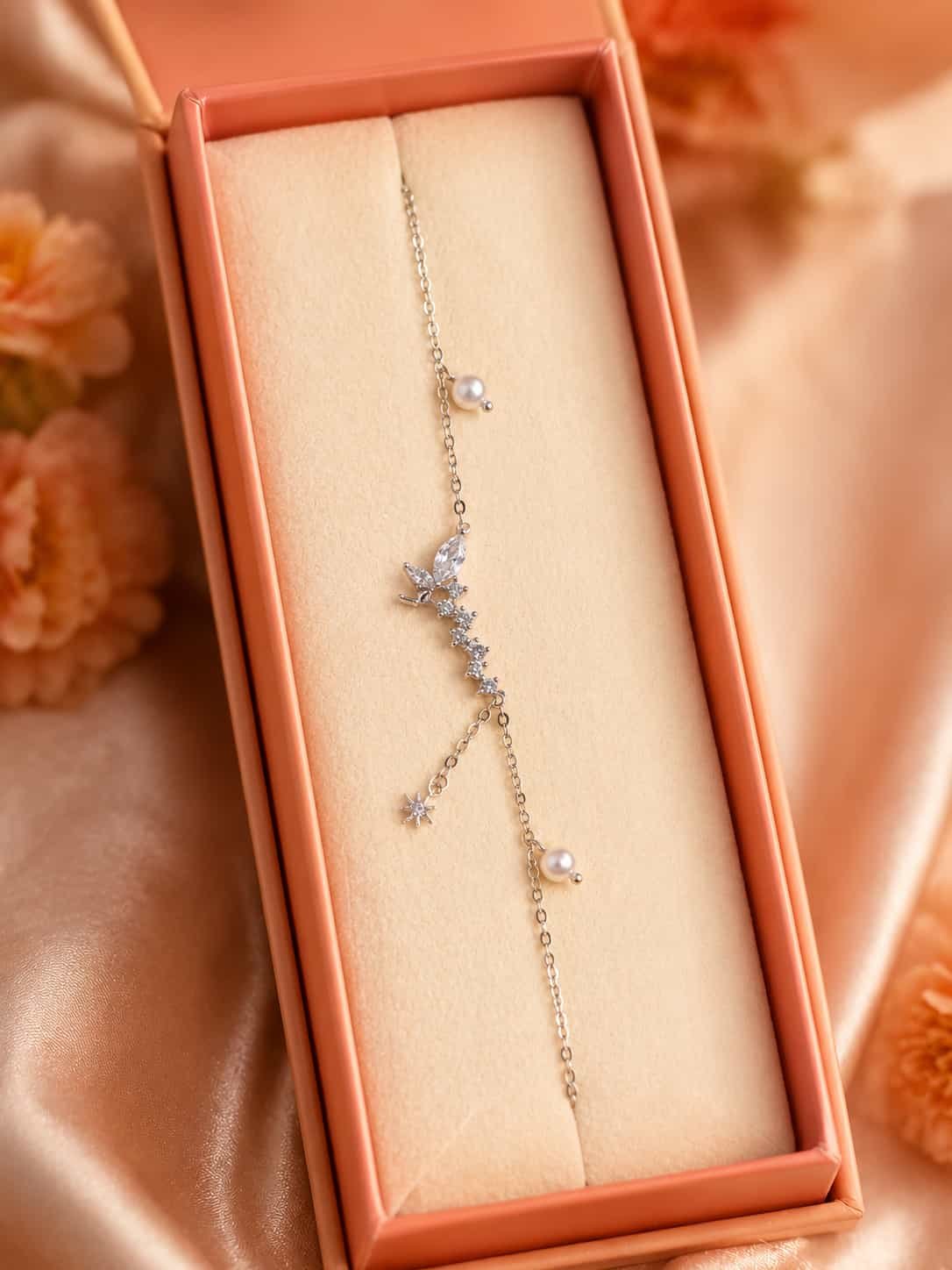 Butterfly and pearl charm bracelet with sparkling stones presented in an elegant jewellery gift box