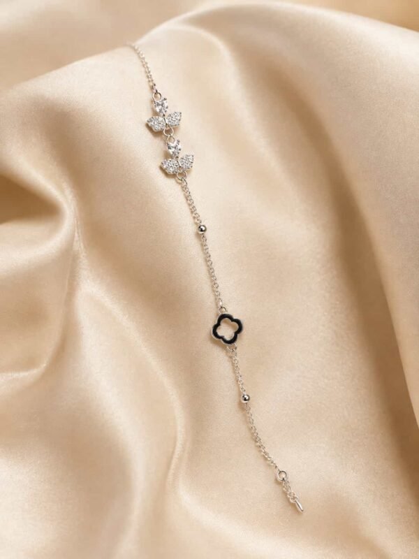 Noir Belle silver-tone butterfly bracelet with sparkling butterfly motifs and black clover accent on champagne satin