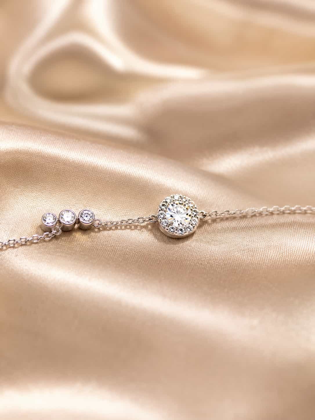 Close-up of round halo centre stone and three-stone detail on Celeste sparkle bracelet