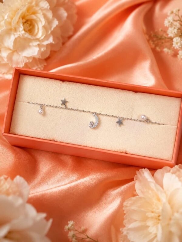 Moon, star and pearl charm bracelet displayed in jewellery gift box with sparkling crescent charm