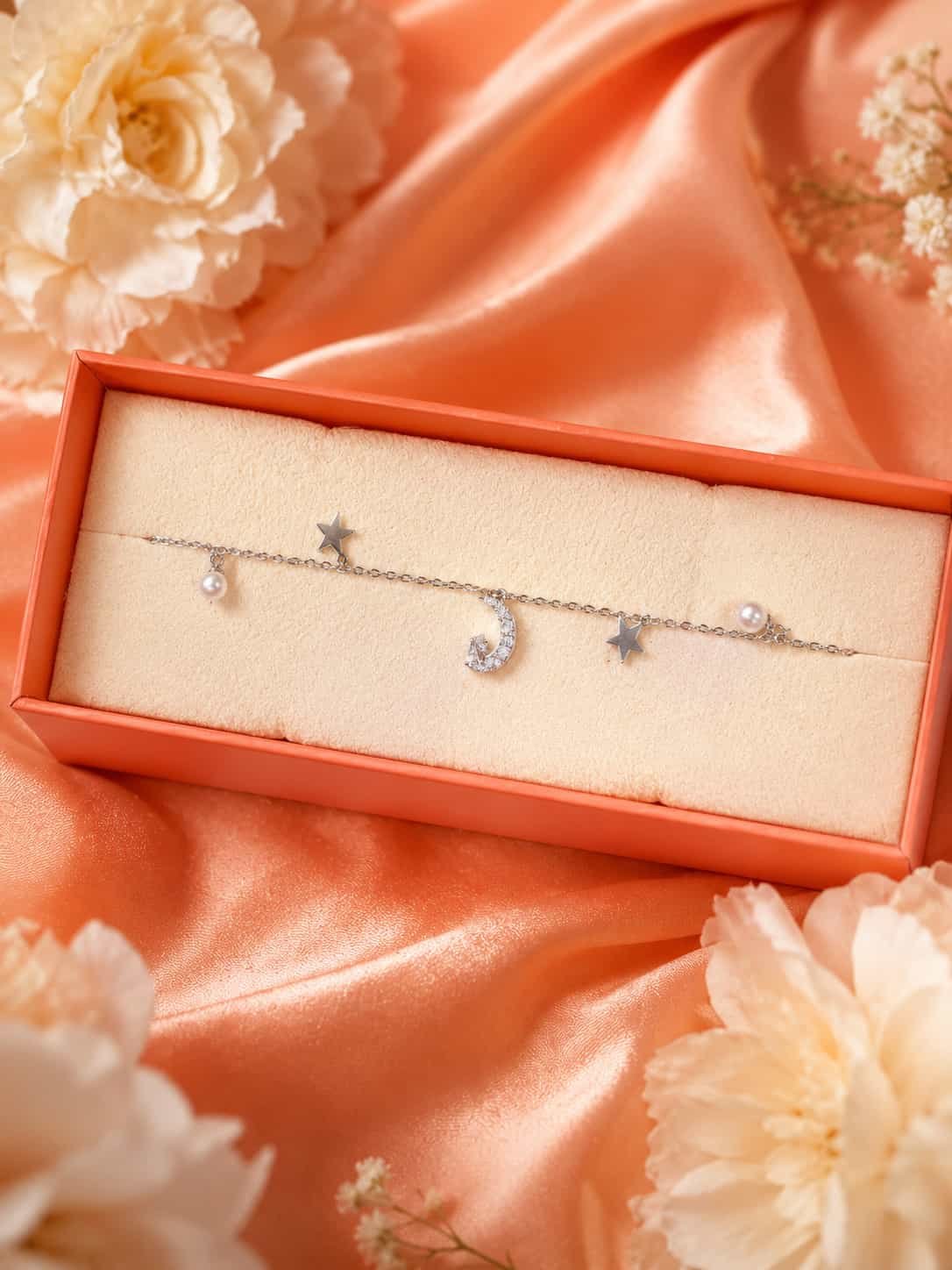 Moon, star and pearl charm bracelet displayed in jewellery gift box with sparkling crescent charm